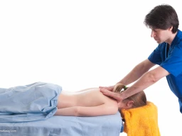 Massage therapist administering to a client. Massage techniques applied on trapezius.
