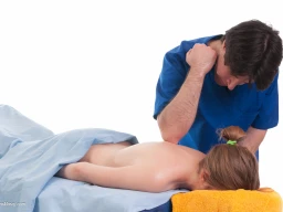 Massage therapist administering to a client. Elbow technique applied on back.